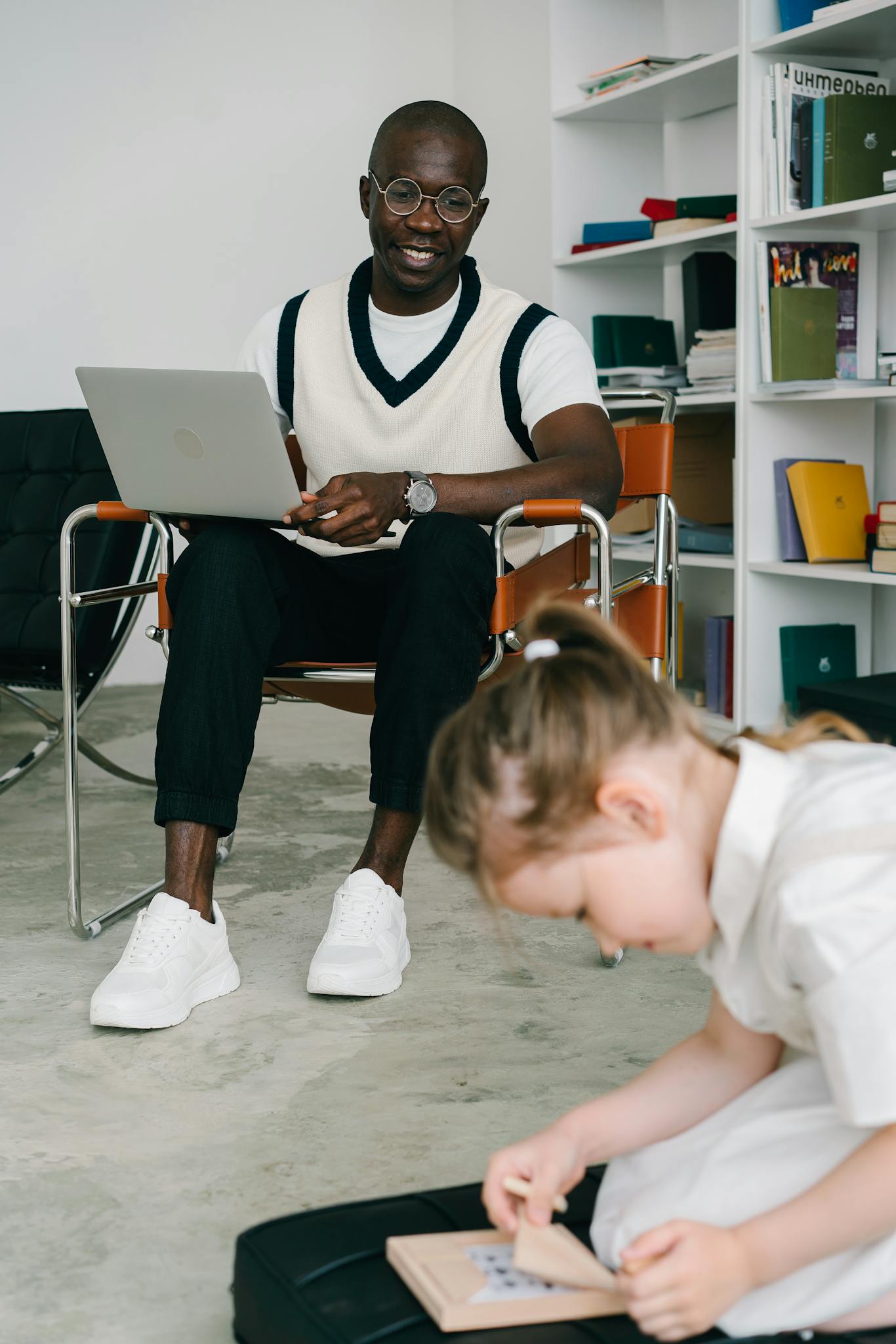 Therapist observing a child engaged in educational activity indoors.